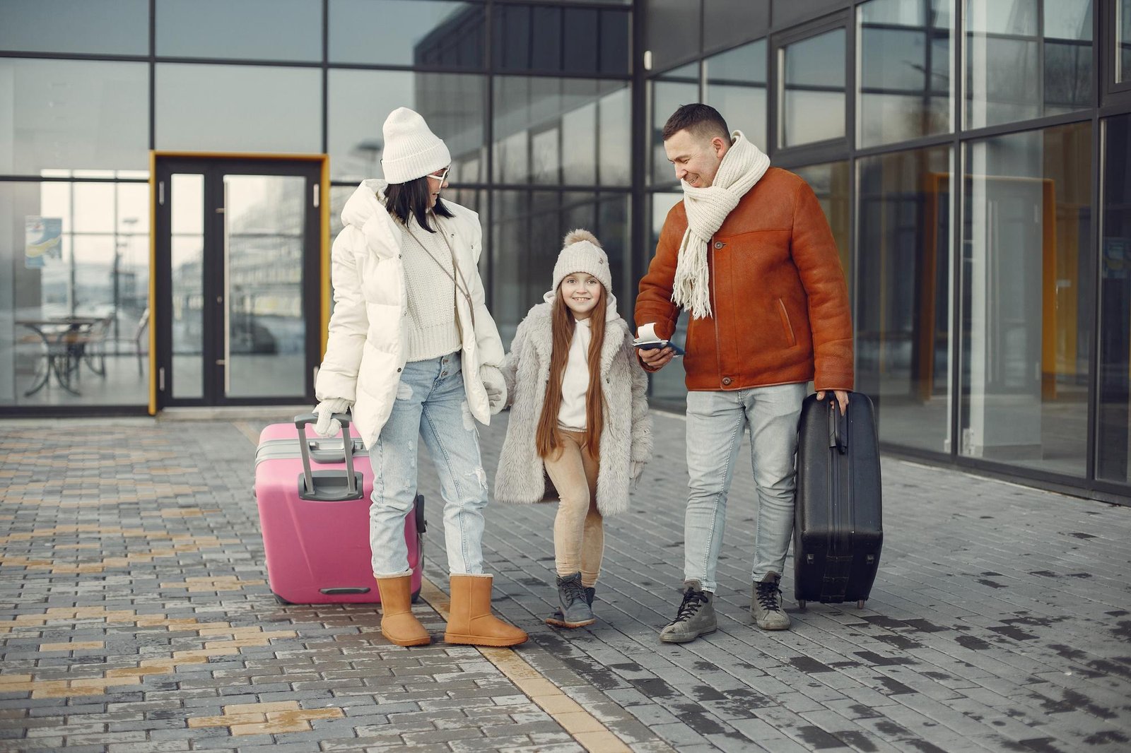 mother-father-daughter-with-luggage-going-from-airport-terminal